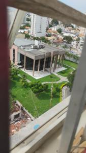een raam met uitzicht op een gebouw bij Flat Aconchegante e Tranquilo in Campos dos Goytacazes +2 foto's
