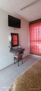 a room with a table and a mirror on the wall at HOTEL VILLAS XAIBA in Puerto Escondido