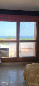 a room with a window with a view of the ocean at HOTEL VILLAS XAIBA in Puerto Escondido