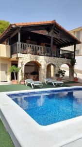 a house with a swimming pool in front of a building at Chalet con piscina privada in Borriol
