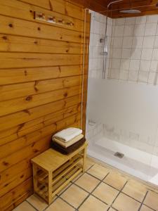 a bathroom with a shower and a wooden wall at Chalet con piscina privada in Borriol