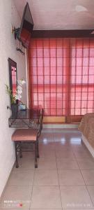 a room with a table and a chair and a red wall at HOTEL VILLAS XAIBA in Puerto Escondido