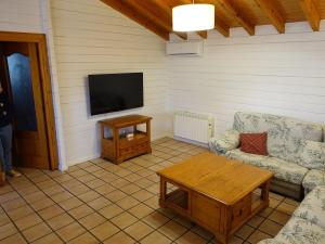 a living room with a tv and a couch and a table at Chalet con piscina privada in Borriol