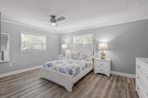 a bedroom with a bed and two night stands and two windows at Silver Palm Retreat in Sarasota +34 photos