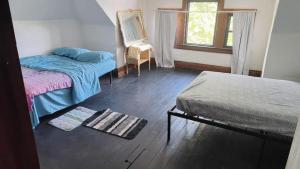a room with two beds and a window and a chair at Valley and city views in Steubenville
