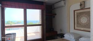 a bedroom with a window with a view of the ocean at HOTEL VILLAS XAIBA in Puerto Escondido