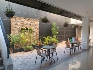 a patio with tables and chairs and potted plants at Okawango Hotel in Girardot