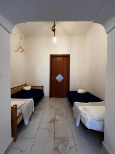 una camera con due letti e una porta di 'A tarantella a Napoli