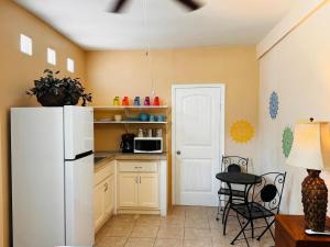 a kitchen with a white refrigerator and a table at Vaquita Marina House in Puerto Peñasco