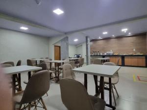 an empty room with tables and chairs and a counter at Executive Hotel Aguas lindas GO in Macacos