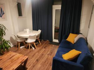Una sala de estar con un sofá azul y una mesa. en Place to stay Croydon, en Thornton Heath