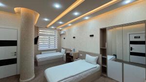 Un dormitorio con una cama y un escritorio. en Chinor Hotel Fergana, en Ferganá