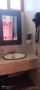 a bathroom with a sink and a mirror at HOTEL VILLAS XAIBA in Puerto Escondido