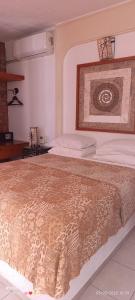 a bedroom with a large bed with a brown blanket at HOTEL VILLAS XAIBA in Puerto Escondido