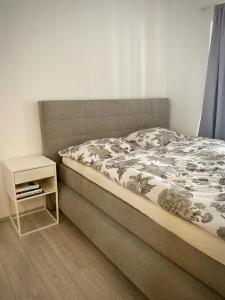 un letto in una camera da letto con comodino accanto ad esso di MIMIs Lakeside Apartment - NEWLY RENOVATED a Gmunden