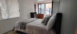 a bedroom with a bed with pillows and a window at hab chicamocha in Sogamoso