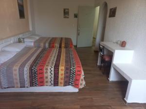 a bedroom with two beds and a desk and a bed at HOTEL VILLAS XAIBA in Puerto Escondido