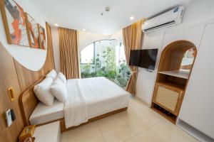 a hotel room with a bed and a television at Azure Bay Hotel in Ha Long
