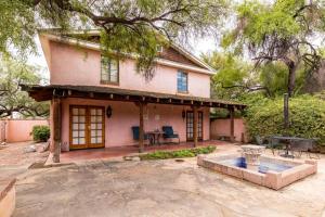 Una pequeña casa rosa con una mesa y un patio. en Vibrant 2BR DT Living, Stylish & Serene Stay, en Tucson