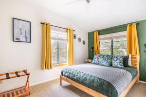 1 dormitorio con 1 cama y una ventana con cortinas amarillas en Vibrant 2BR DT Living, Stylish & Serene Stay, en Tucson