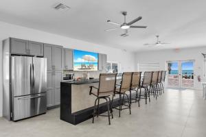 a kitchen with a bar with chairs and a refrigerator at Ocean Isles Peace and Serenity in Marathon