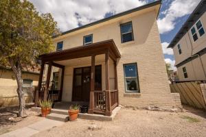 a house with a front porch with a fence at Spring Serenity Chic 1BR Apt Walk to UofA in Tucson