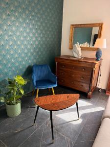 a living room with a blue chair and a mirror at Lorenzo s House Nearby Leaning Tower Free Parking in Pisa