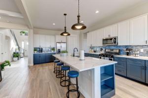 a kitchen with blue cabinets and a large island with stools at Cozy Montana Escape Near Bozeman & Yellowstone in Belgrade