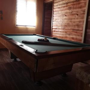 a pool table in a living room with at Cabaña Arelys in Cedro +6 photos