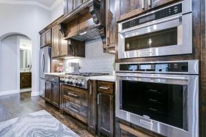 una cucina con elettrodomestici in acciaio inossidabile e mobili in legno di Spacious and Modern 4BR 2BA 5MintoDFW a Lewisville