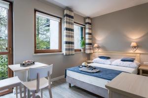 a bedroom with a bed and a table and chairs at Farys in Jastrzębia Góra