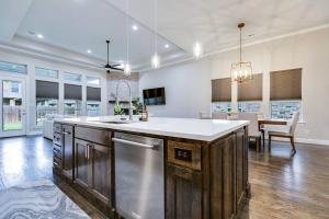 una cucina con un'ampia isola con ripiano bianco di Spacious and Modern 4BR 2BA 5MintoDFW a Lewisville