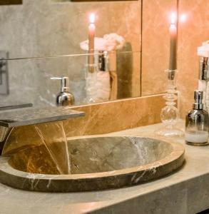 a bathroom sink with two candles and a mirror at Reno Villa 4Br in Sheikh Zayed