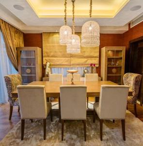 a dining room with a wooden table and chairs at Reno Villa 4Br in Sheikh Zayed