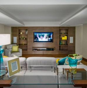 a living room with a white couch and a tv at Reno Villa 4Br in Sheikh Zayed
