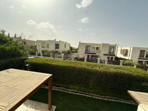a garden with a hedge and a wooden table at Reno Villa 4Br in Sheikh Zayed