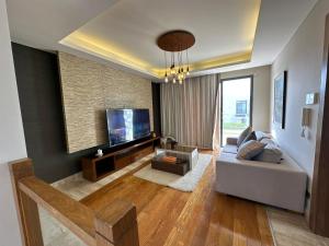 a living room with a couch and a flat screen tv at Reno Villa 4Br in Sheikh Zayed +4 photos