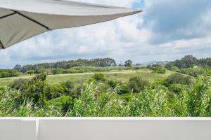 a view of a field from an umbrella at Casa do Mar - Almograve - Magnífico terraço com vista para o campo in Almograve
