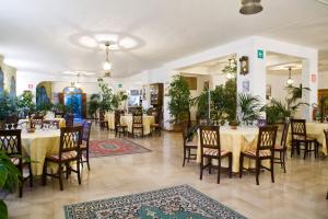 a dining room with tables and chairs and plants at Hotel Miravalle in Misilmeri