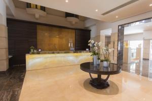 a lobby with a table with flowers on it at Maritim Antonine Hotel & Spa in Mellieħa +37 photos