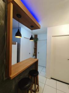 a kitchen with two stools and a counter with two lights at Cantinho da harmonia-Morada Nova in Petrolina +15 photos
