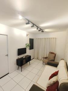 a living room with a couch and a tv at Cantinho da harmonia-Morada Nova in Petrolina