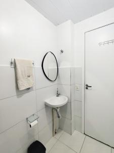 a white bathroom with a sink and a mirror at Cantinho da harmonia-Morada Nova in Petrolina