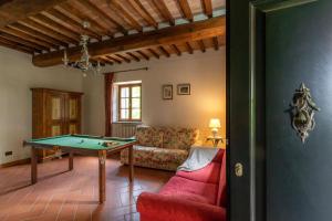 Una sala de estar con una mesa de billar y un sofá. en Tenuta Le Caselle, en Subbiano