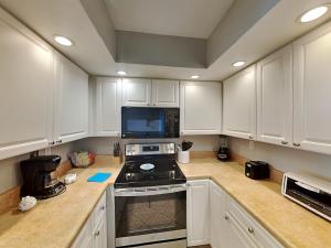 a kitchen with white cabinets and a stove top oven at Perdido Sun #410 in Perdido Key +24 photos