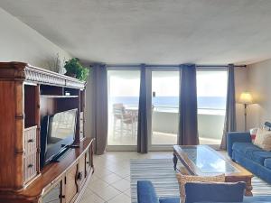 a living room with a blue couch and a tv at Perdido Sun #410 in Perdido Key