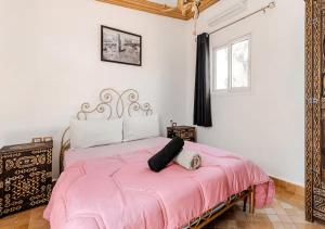 a bedroom with a pink bed and a window at 16 Riads in Marrakesh