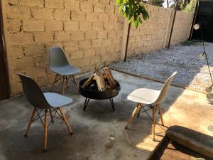 three chairs and a fire pit in a yard at Bosque escondido in Valle de Bravo