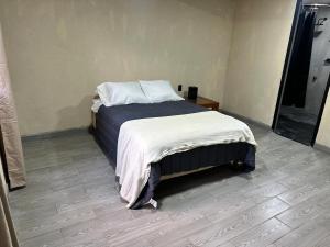 a bedroom with a bed with a white blanket at Bosque escondido in Valle de Bravo