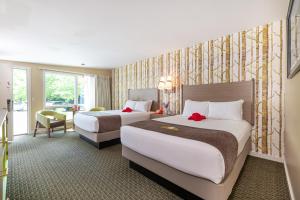 a hotel room with two beds and a desk at Bar Harbor Motel in Bar Harbor